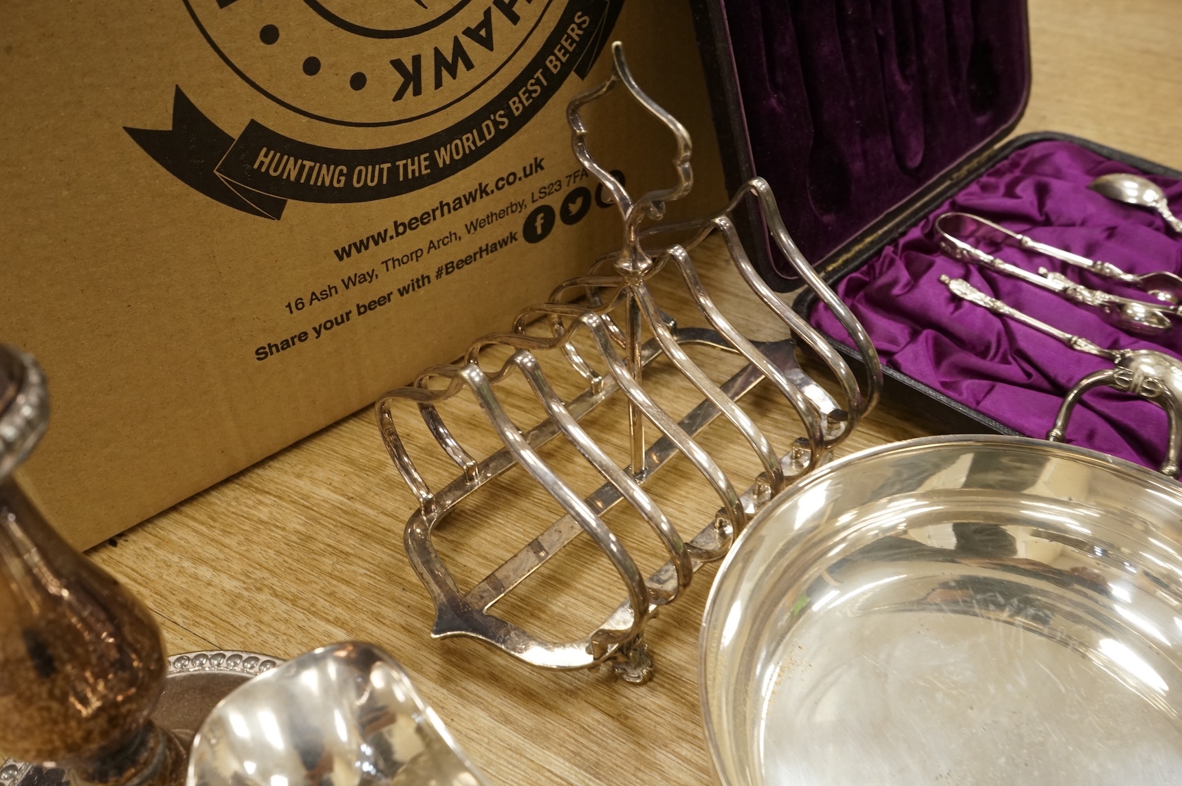 A quantity of assorted plated wares, including flatware, a tea caddy, a chatelaine, a toast rack, a sauceboat, a butter dish and a pair of candlesticks, etc.